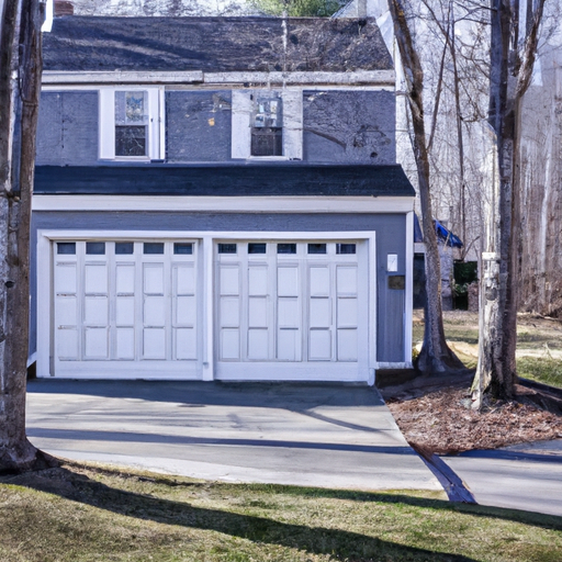 Modern steel-paneled garage door on a Sudbury, MA Colonial home with driveway and bare winter trees